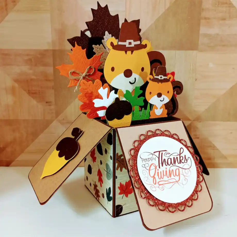 A cute pop-up card with a cartoon squirrel family, autumn leaves, acorns, and a "Happy Thanks Giving" message on the front. A delightful way to send happy thanksgiving messages to friends and family.