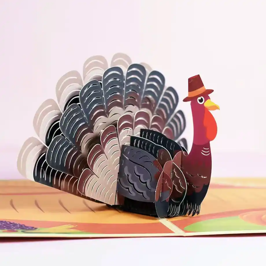 A detailed 3D pop-up card featuring a colorful turkey wearing a pilgrim hat, set against a soft background. A creative option for expressing happy thanksgiving messages.