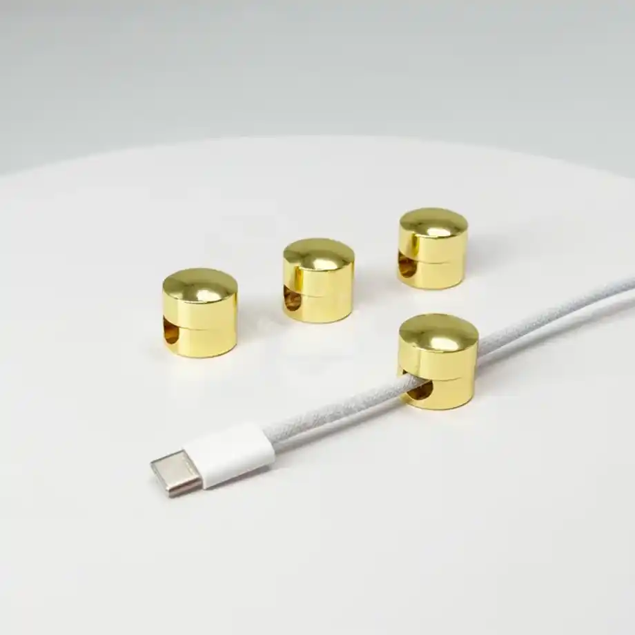 Set of four gold cable holders neatly organizing a USB-C cable, ideal as a thoughtful gift to accompany birthday wishes for a coworker.