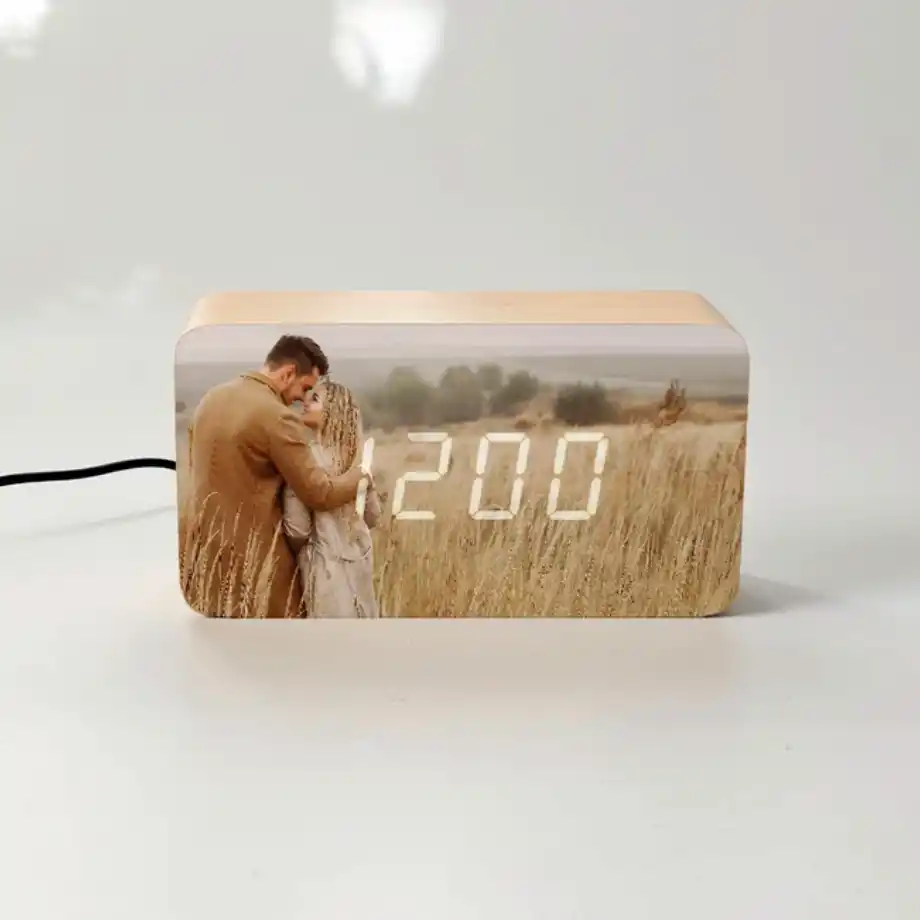 Good morning message for her: A personalized wooden digital clock displaying 12:00, with a romantic engraved photo of a couple embracing in a wheat field.