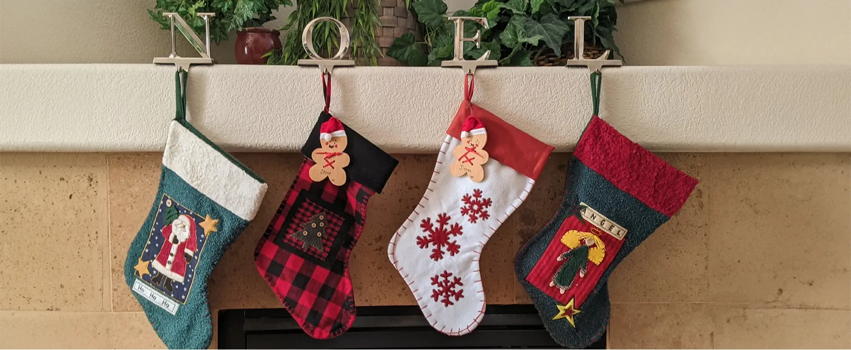 A cozy holiday mantel with four colorful Christmas stockings, each featuring festive designs like Santa, snowflakes, and angels. These stockings are perfect for holding stocking stuffers for a husband, family members, or loved ones.