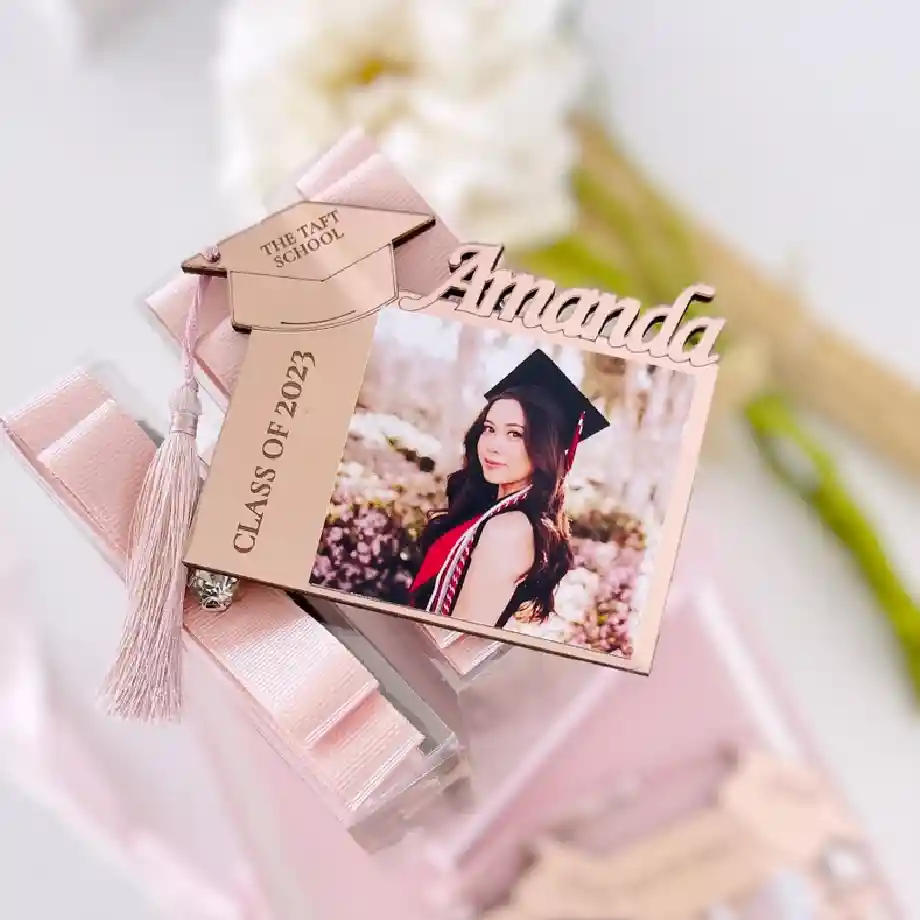 Personalized wooden graduation photo frame with a cap-shaped tag, tassel, and engraved name, making a sentimental keepsake