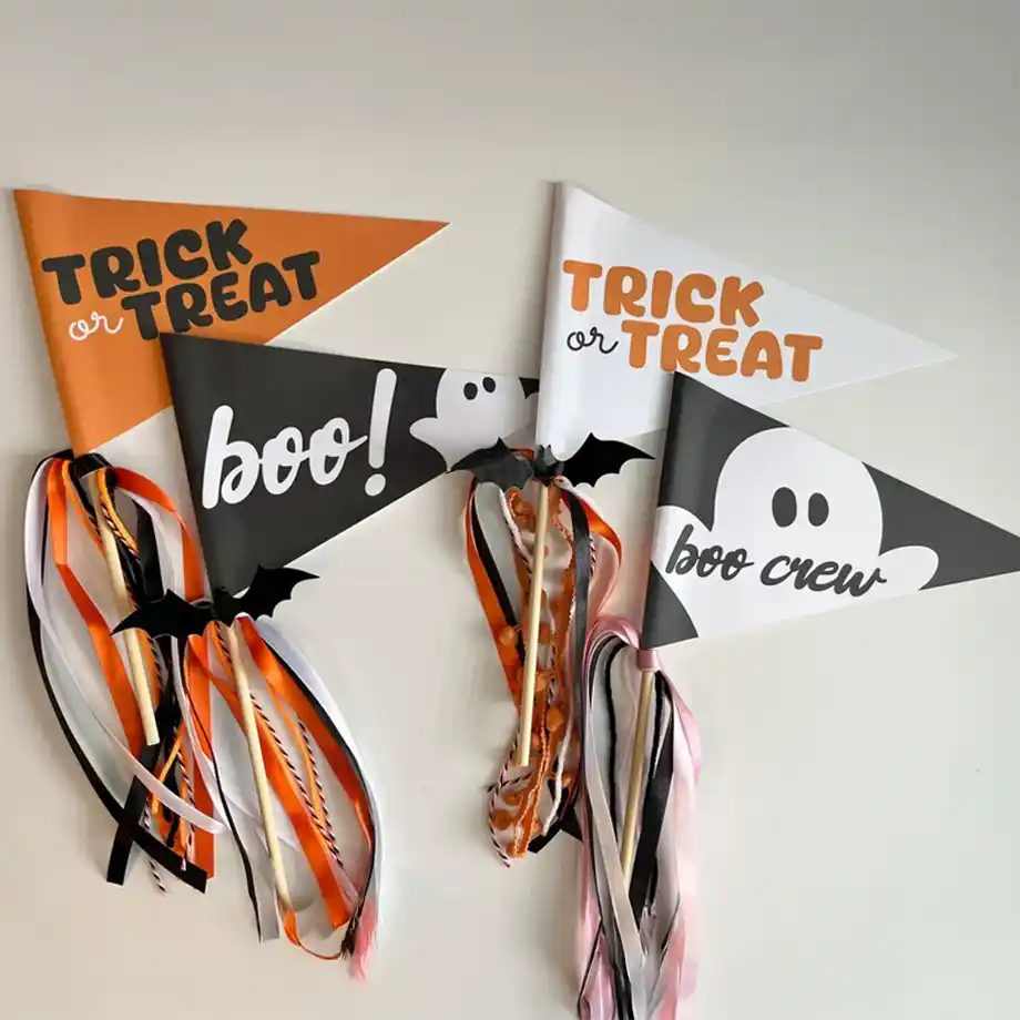 A set of Halloween-themed pennant flags in black, white, and orange, featuring phrases like "Trick or Treat," "Boo!," and "Boo Crew." Each flag is decorated with flowing ribbons and small bat cutouts, making them a perfect addition to a spooky boo basket or Halloween celebration.