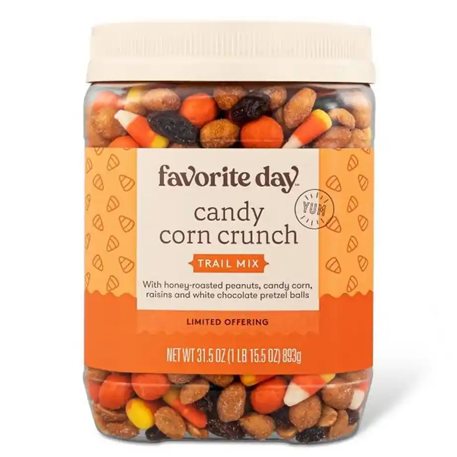 A jar of Favorite Day Candy Corn Crunch Trail Mix, packed with honey-roasted peanuts, candy corn, raisins, and white chocolate pretzel balls — the perfect festive snack to sweeten up any Halloween boo basket.