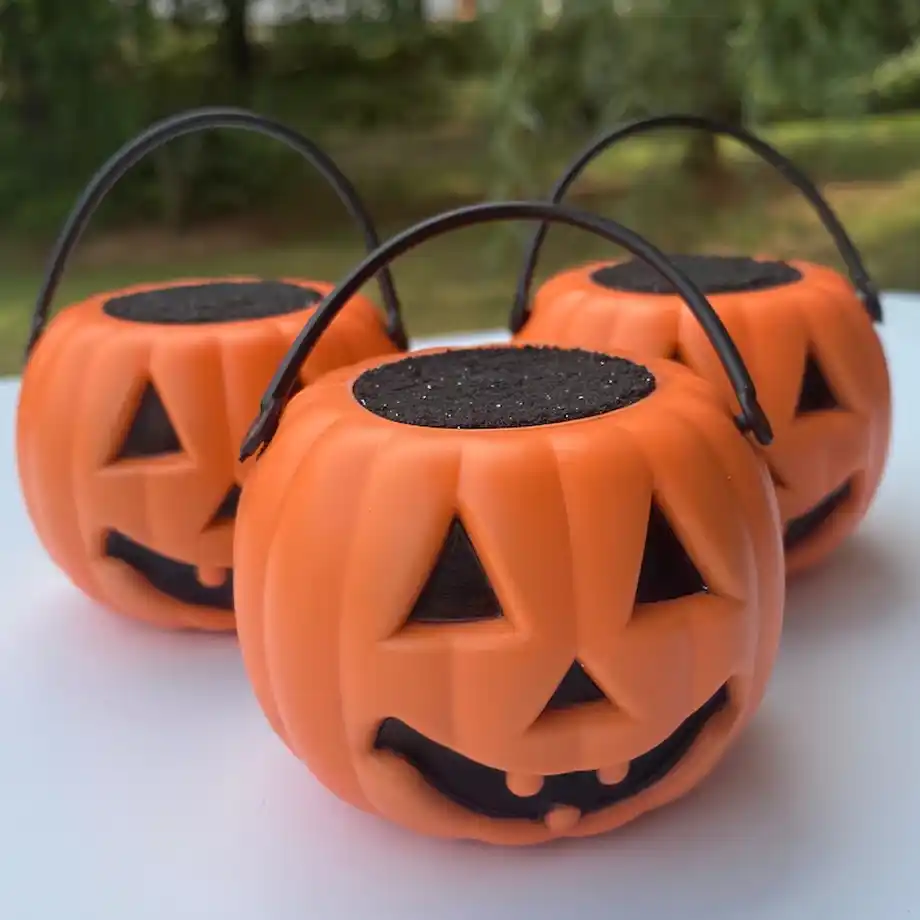 A black Jack O' Lantern-themed Halloween bath bomb that fizzes to reveal a spooky surprise, perfect for creating a hauntingly relaxing bath experience or adding a festive touch to a Halloween boo basket.