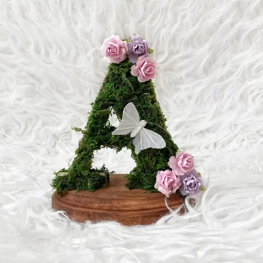 A charming wood stand adorned with fairy moss, perfect for displaying personalized letters or decor. A beautiful addition for anyone looking for fairy names for girls to create an enchanted, nature-inspired setting.