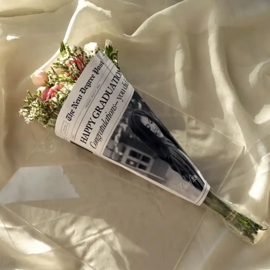 A creative newspaper-wrapped flower bouquet, combining eco-friendliness with a stylish design, making it a unique and thoughtful graduation gift idea.