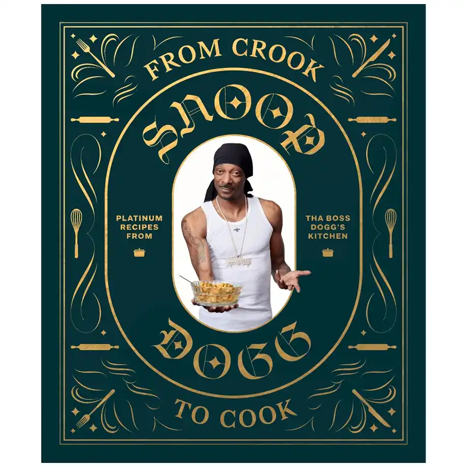 The cover of From Crook to Cook: Platinum Recipes from Tha Boss Dogg’s Kitchen by Snoop Dogg, featuring a stylish design with gold lettering on a dark green background. Snoop Dogg is at the center, wearing a white tank top, a black durag, and a chain, holding a bowl of food with a confident pose. The cookbook blends hip-hop flair with comfort food recipes, making it a unique and entertaining choice for white elephant gift ideas.