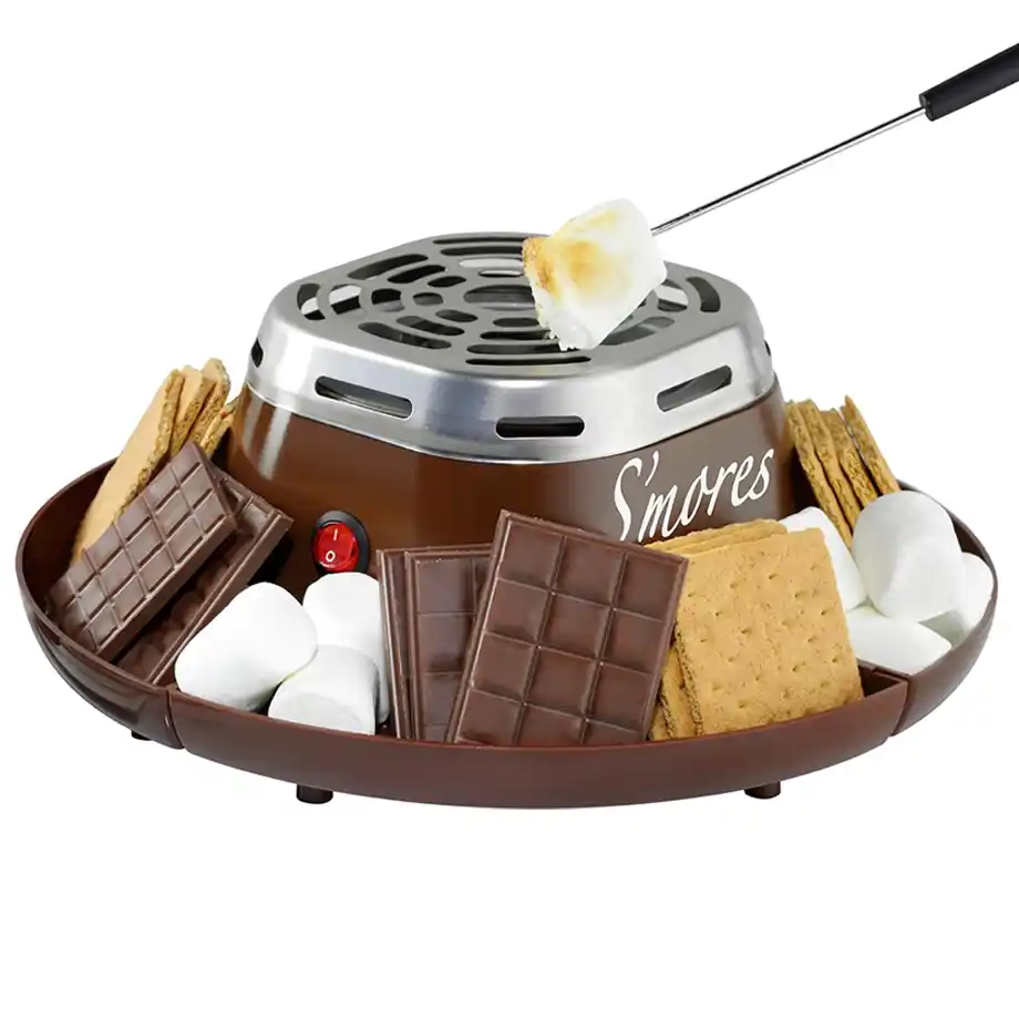 A fun and practical indoor electric s’mores maker, surrounded by graham crackers, chocolate bars, and marshmallows—one of the best white elephant gift ideas for holiday parties and gatherings.