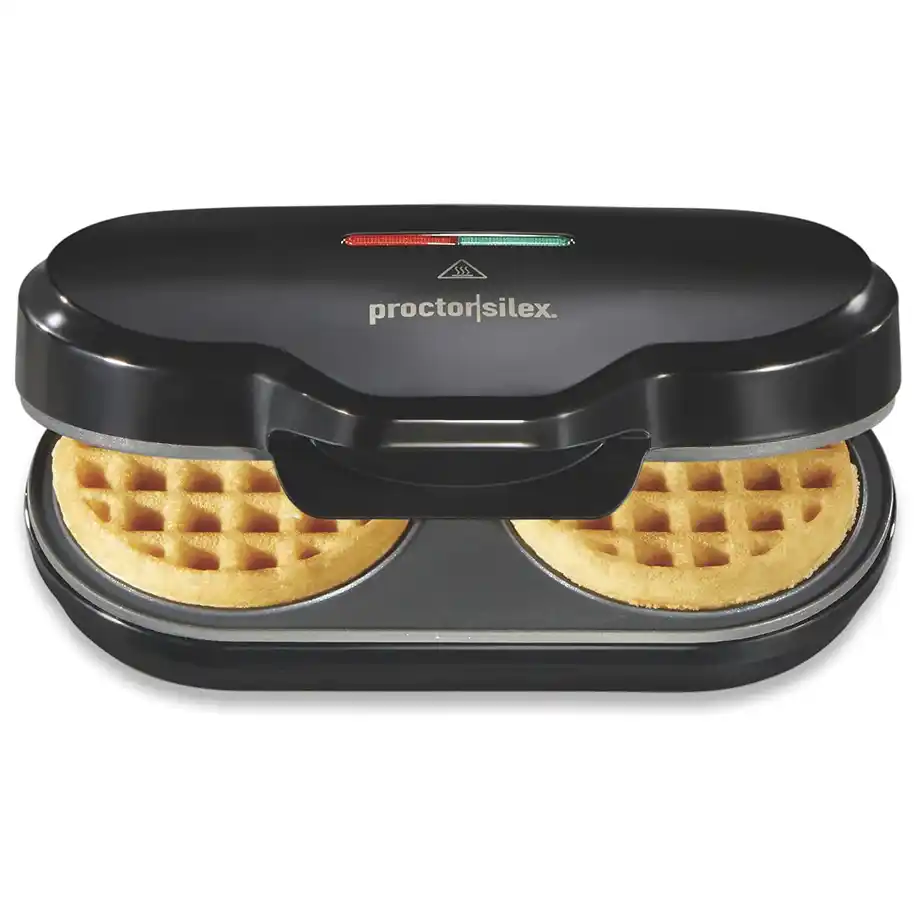 A black Proctor Silex waffle maker cooking two golden waffles, making it a great option for white elephant gift ideas. Compact and easy to use, perfect for breakfast lovers and kitchen gadget enthusiasts.