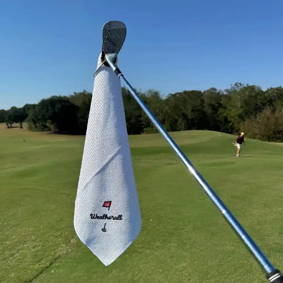 A white custom monogrammed golf towel with a magnetic attachment, perfect for groomsmen, bachelor parties, and Father's Day gifts. A stylish and functional golf accessory.