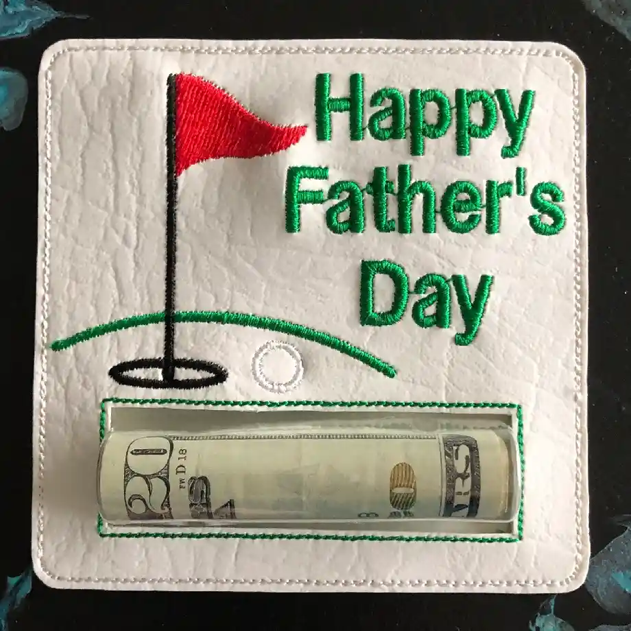 A Father's Day golf-themed money holder with embroidered text, a red flag, and a putting green design. Includes a clear cash pocket, making it a thoughtful and unique golf gift for dads who love the sport.