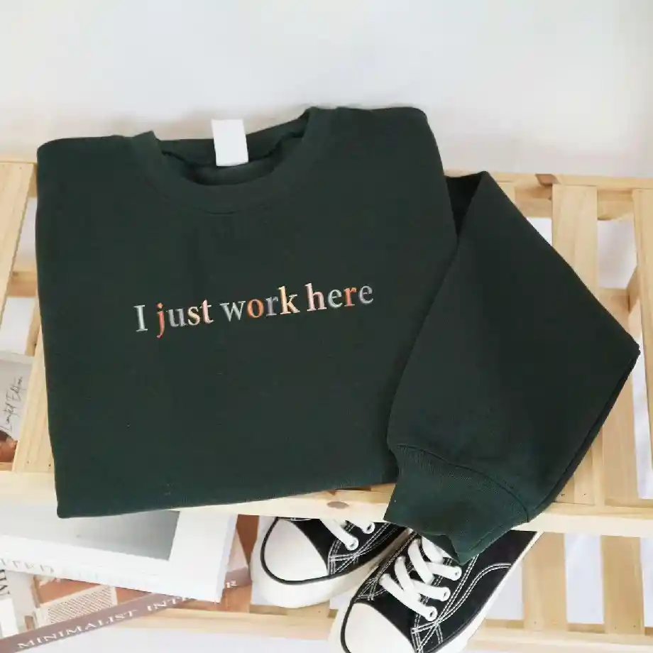 Cozy embroidered sweatshirt with the phrase "I Just Work Here," perfect for coworkers, project managers, and office humor lovers. A great gift idea for coworkers who appreciate sarcasm and fun office apparel.